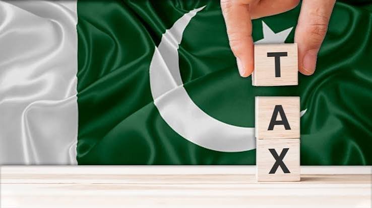 Pakistani flag with wooden TAX letter blocks