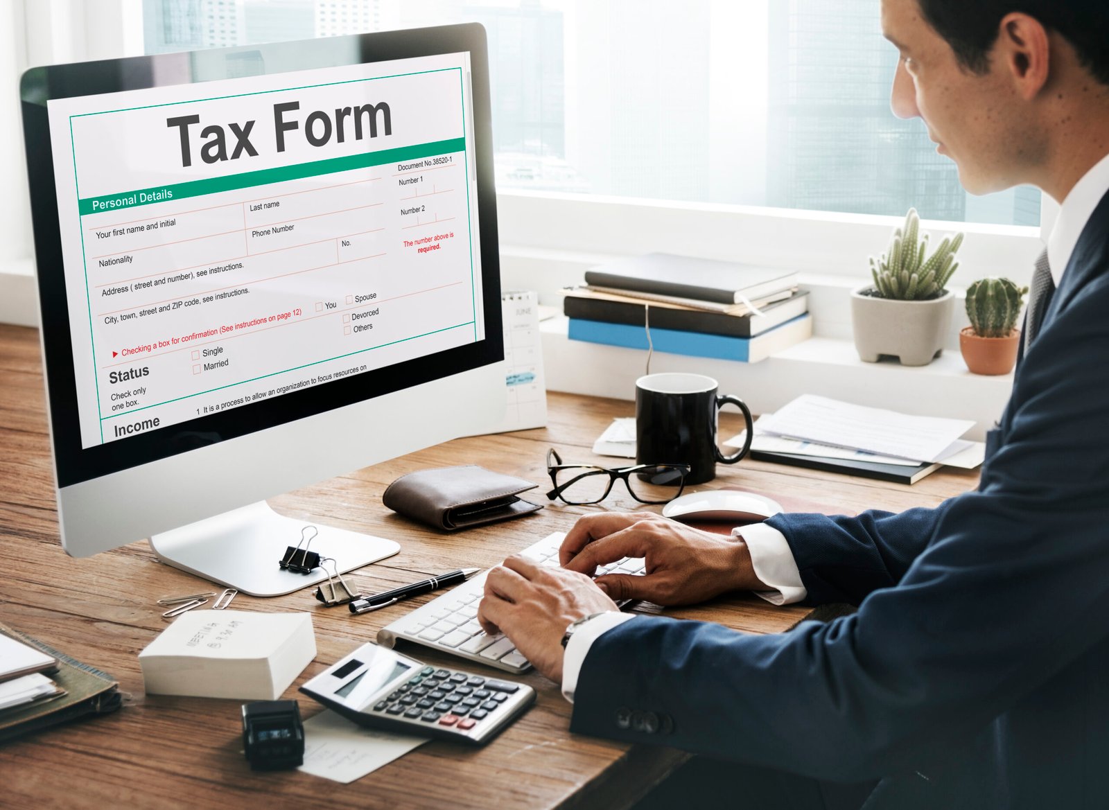Person filling out a tax form on a computer at a desk